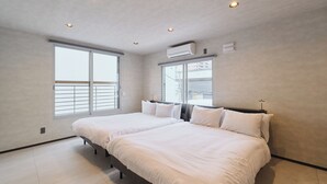 A bedroom with two beds, large windows, ceiling lights, and an air conditioning unit. - Sauna & Villa Yu to Yo (Chuo-ku, Sapporo City)