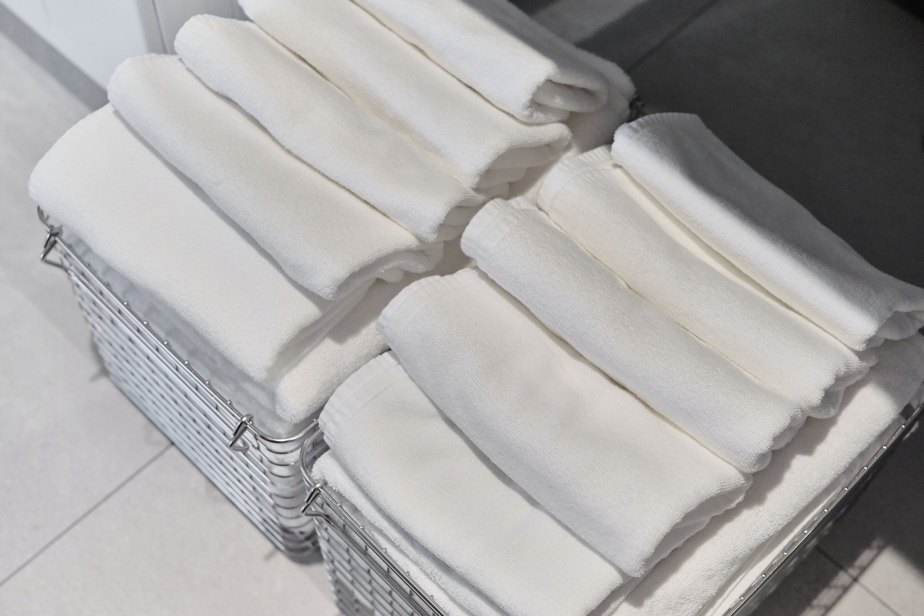 A stack of white towels in a metal basket.