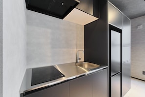 Una cocina moderna con electrodomésticos de acero inoxidable, un grifo elegante y un diseño minimalista.