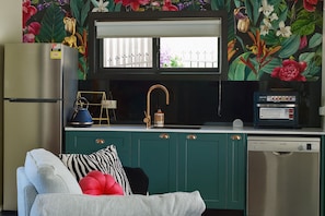A kitchen with a built-in oven, a sink with a gold faucet, and a window above the sink. - Hervey Bay: first-class service at Bay Bliss Haven, a unique, tranquil setting. (Point Vernon)