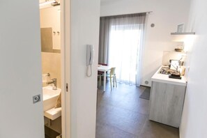 Ein Hotelzimmer mit Bad, Essbereich und Küchenzeile.