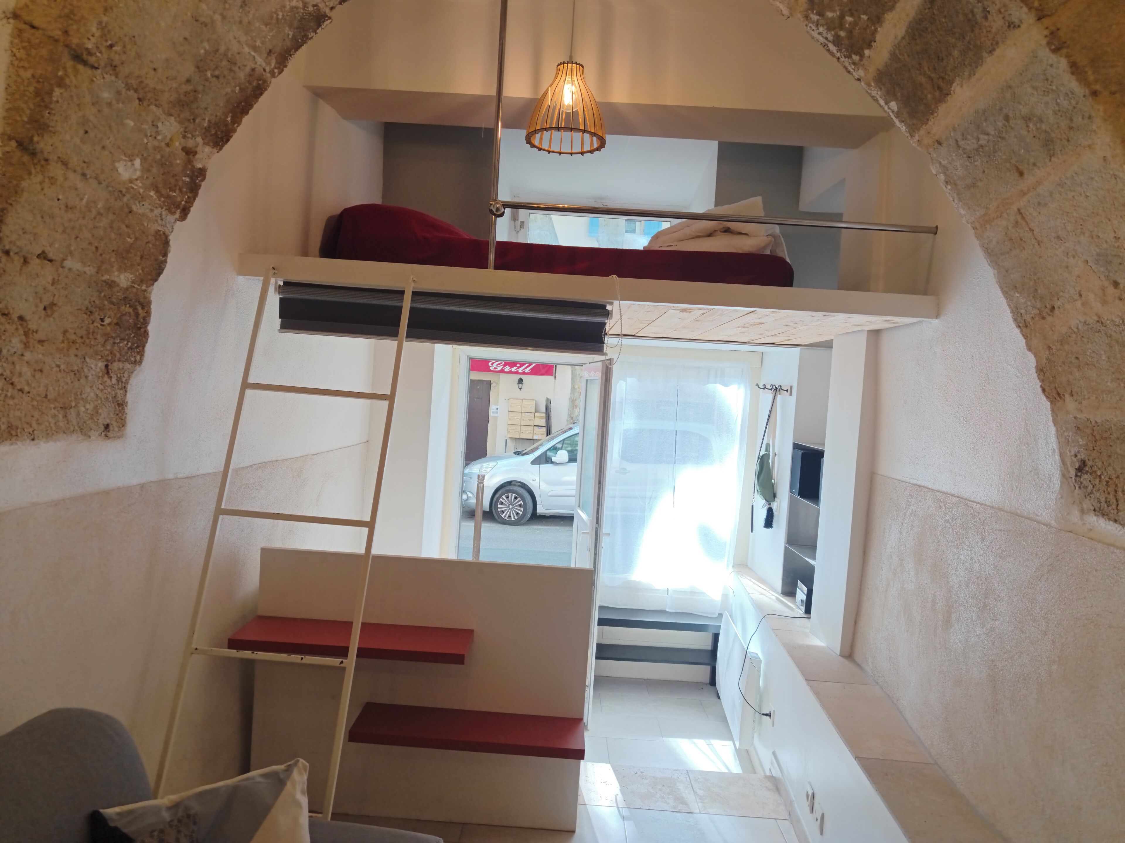 Camera in stile loft con letto a castello, una scala e una lampada a sospensione.