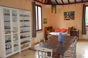 A dining area with a wooden table, chairs, and a cabinet with glass doors.