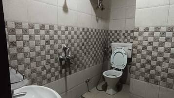 Un baño pequeño con inodoro, lavamanos y calentador de agua instalado en la pared.