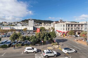 A cityscape with buildings, a parking lot, and a pedestrian crossing. - Te Aro City Stay - Modern Studio for Two (Wellington)