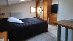 A bedroom with a bed, a desk, a TV, and a wardrobe. - Three rooms at "Chez Valou & Mika" in Mont de Marsan, Landes. (Mont-de-Marsan)