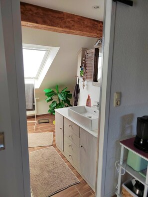 Eine moderne Küche mit Dachfenster, einer großen Pflanze und einer Kaffeemaschine.