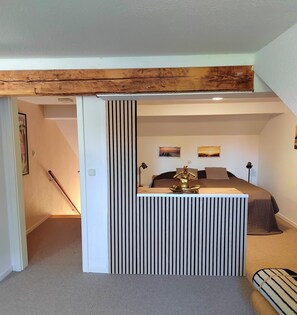 Ein Schlafzimmer mit einem Bett, einem Schreibtisch, einem Stuhl und einer Dekofigur.
