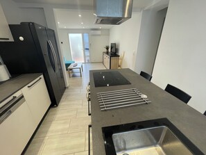 A modern kitchen with a built-in stove, a sink, and a refrigerator. - Very quiet, renovated 58 m2 apartment 100m from the sea (La Seyne-sur-Mer)