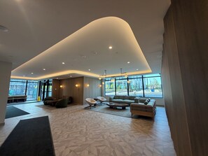Eine geräumige Lobby mit gewölbter Decke, großen Fenstern und modernen Sitzgelegenheiten.