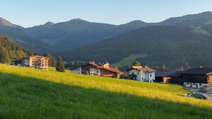 Paisagem montanhosa com fileira de casas numa encosta.