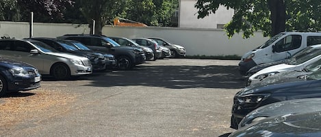 A parking lot with multiple cars and trees.