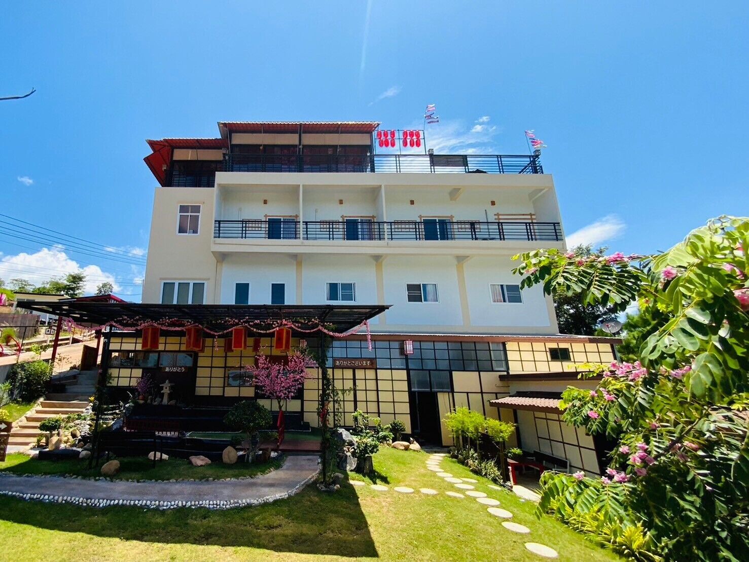A multi-story hotel with a central courtyard, a covered entrance, and a flag on the roof.