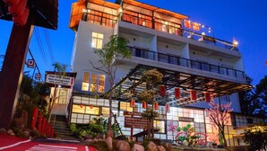 A multi-story hotel with a covered entrance, signage in a foreign language, and a well-maintained garden area. - Sakura Yama Resort (Khaem Son)
