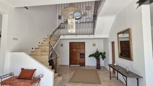 A staircase leading to a second floor, a wooden door, a potted plant, a mirror, and a small table with a vase. - Charming winegrower's farmhouse/villa recently renovated with swimming pool max 14 pers. (Marsillargues)