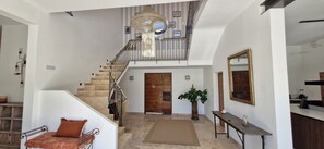A staircase leading to a second floor, a wooden door, a potted plant, a mirror, and a small table with a vase. - Charming winegrower's farmhouse/villa recently renovated with swimming pool max 14 pers. (Marsillargues)