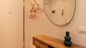 Un bagno con un mobile vanitario in legno, uno specchio e un porta asciugamani a parete.