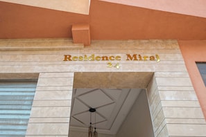 Ein Gebäudeeingang mit einem Schild, auf dem 'Residence Miraj 24' steht.
