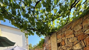 Un muro de piedra, asientos al aire libre y una fuente de agua.