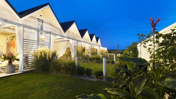 A row of modern, white-roofed cottages with a well-maintained lawn and plants. - Holiday Home With Terrace, Garden, and Pool (Darlowo)