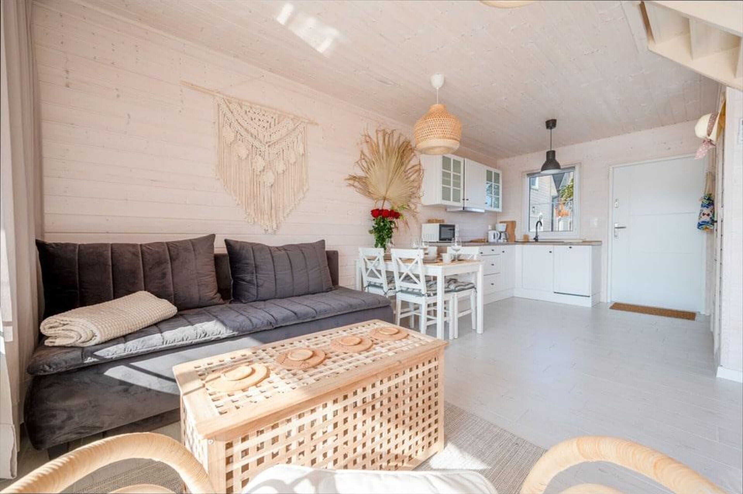 Una sala acogedora con sofá, una mesa de centro de madera y una mesa de comedor con sillas.