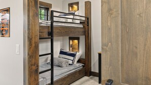 A bunk bed with a wooden frame, a small window, and a door. - Whisper Ridge - Luxury 5 BD - Walk to Social Village (CLE ELUM)