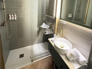 A modern bathroom with a glass-enclosed shower, a vanity with a sink, and a mirror. - Deluxe Apartment With Balcony (Alicante)