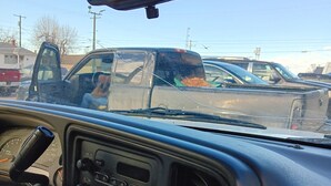 A vehicle's interior with a dashboard, steering wheel, and rearview mirror.