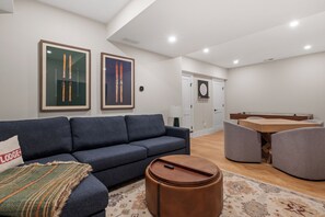 Ein modernes Wohnzimmer mit einer Couch, einem Couchtisch und einem Essbereich mit Tisch und Stühlen.
