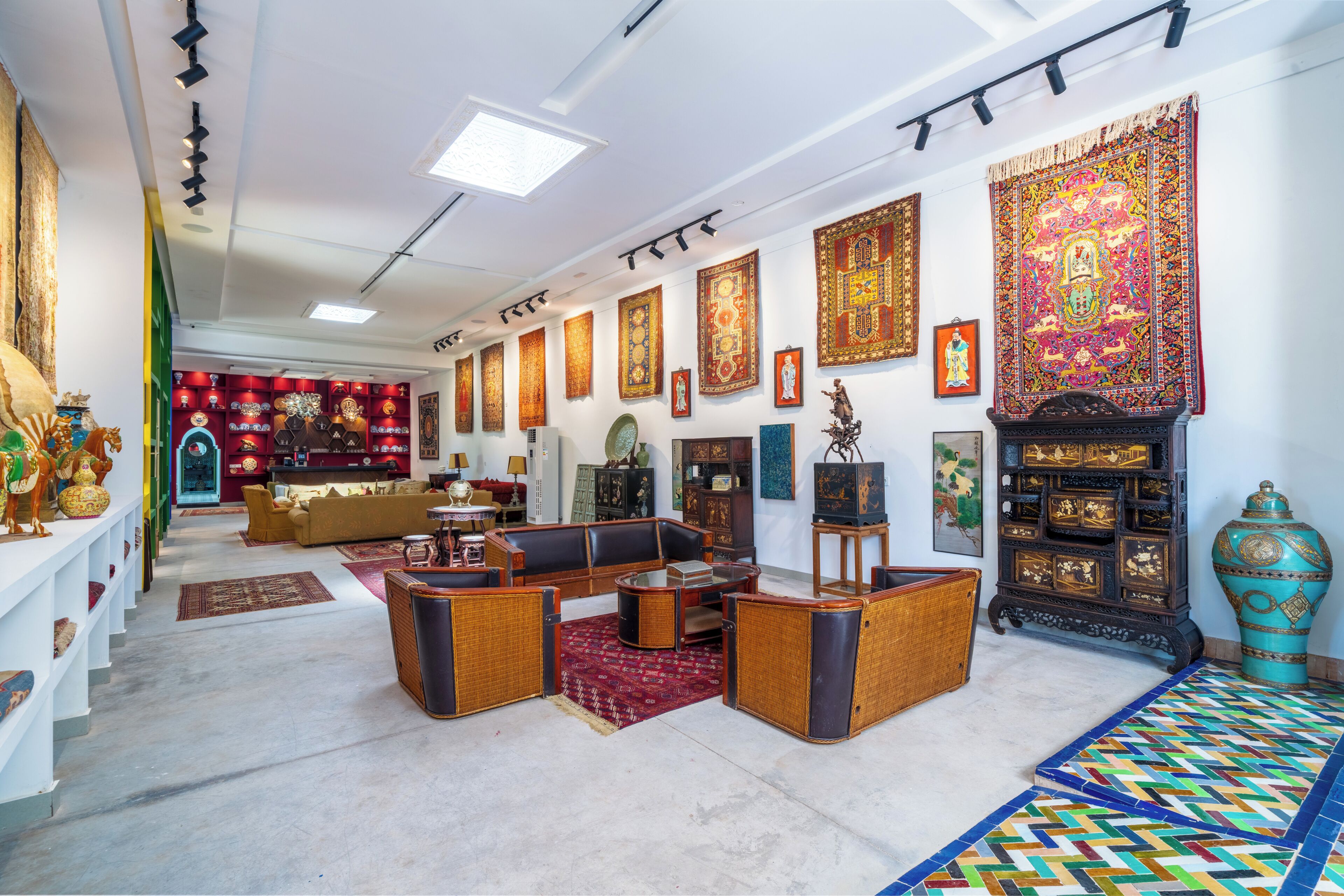Une pièce comprenant un ensemble de canapés, un tapis à motifs et un grand vase décoratif.