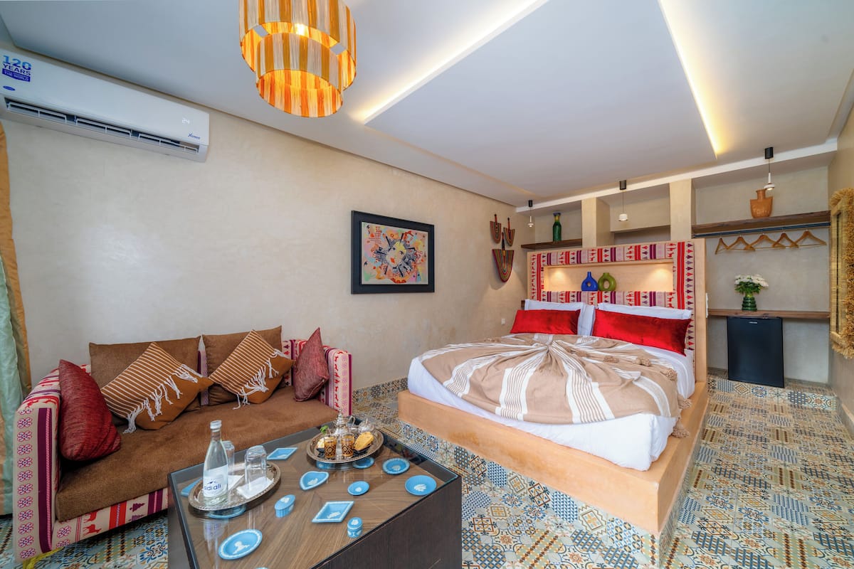 Una camera d'albergo con un letto, un divano e un tavolino con un vassoio di oggetti.