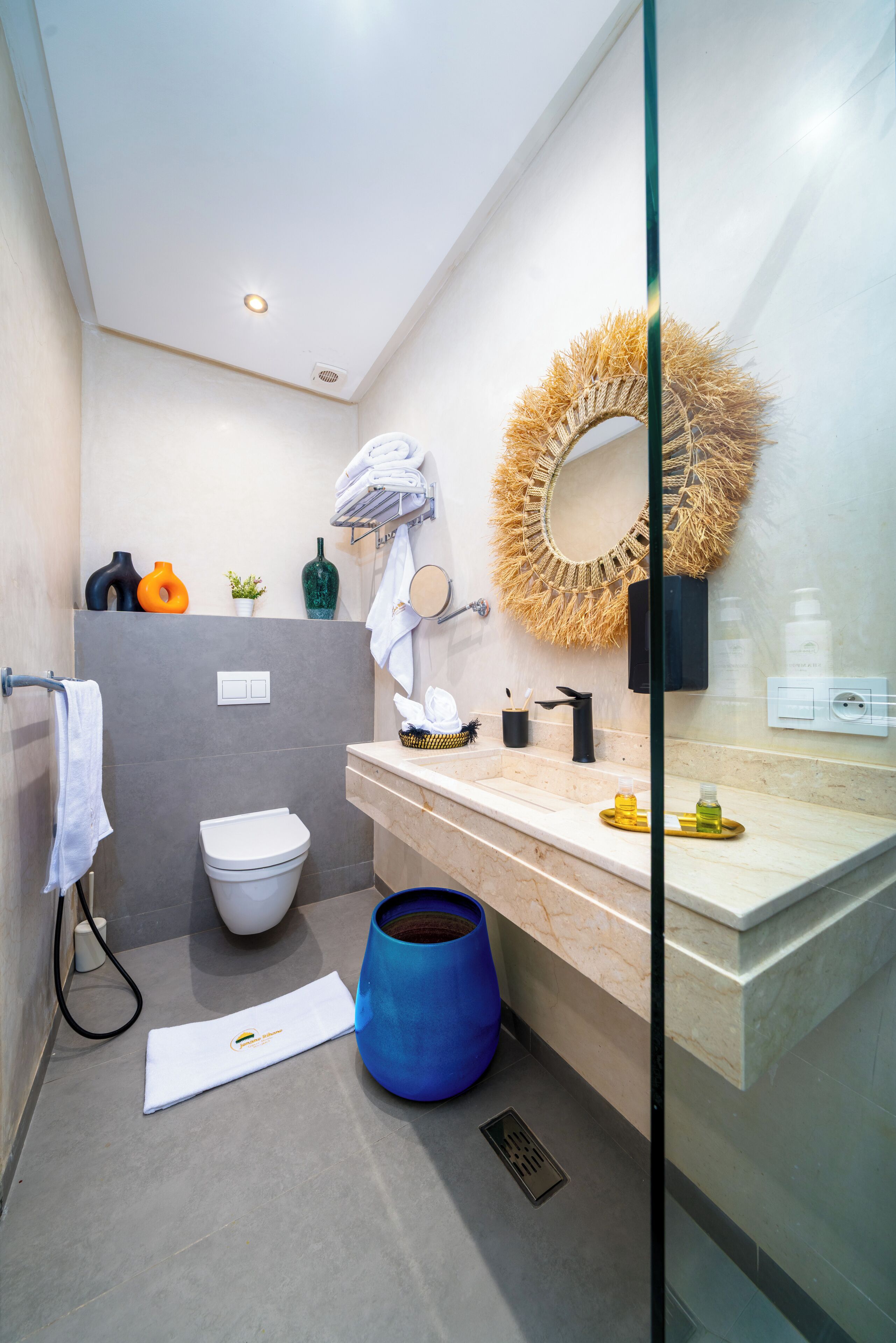 A modern bathroom with a toilet, sink, and mirror.