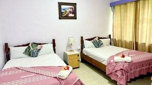 Una habitación de hotel con dos camas, una mesita de noche, un cuadro enmarcado en la pared y una ventana con cortinas.