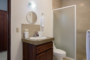 A bathroom with a sink, mirror, towel rack, and toilet. - Surf Shacks Apartment #3 (Hacienda Iguana)