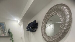 A bathroom with a toilet, sink, mirror, towel rack, and a decorative rug. - Carnegie Library Christie apartment (Swinton)