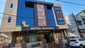 Un edificio con un cartel que dice 'HOTEL SANMAT' y 'HABITACIONES CON AIRE ACONDICIONADO DISPONIBLES'.