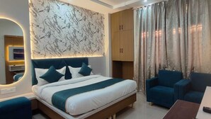 Una habitación de hotel moderna con cama, zona de estar, televisor y baño.
