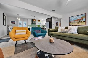 Ein modernes Wohnzimmer mit Sofa, Sessel und Couchtisch.