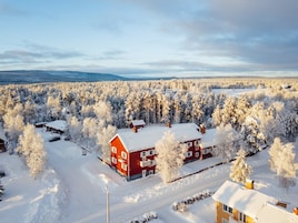 Un edificio rojo rodeado de árboles cubiertos de nieve, con vistas claras del bosque circundante.