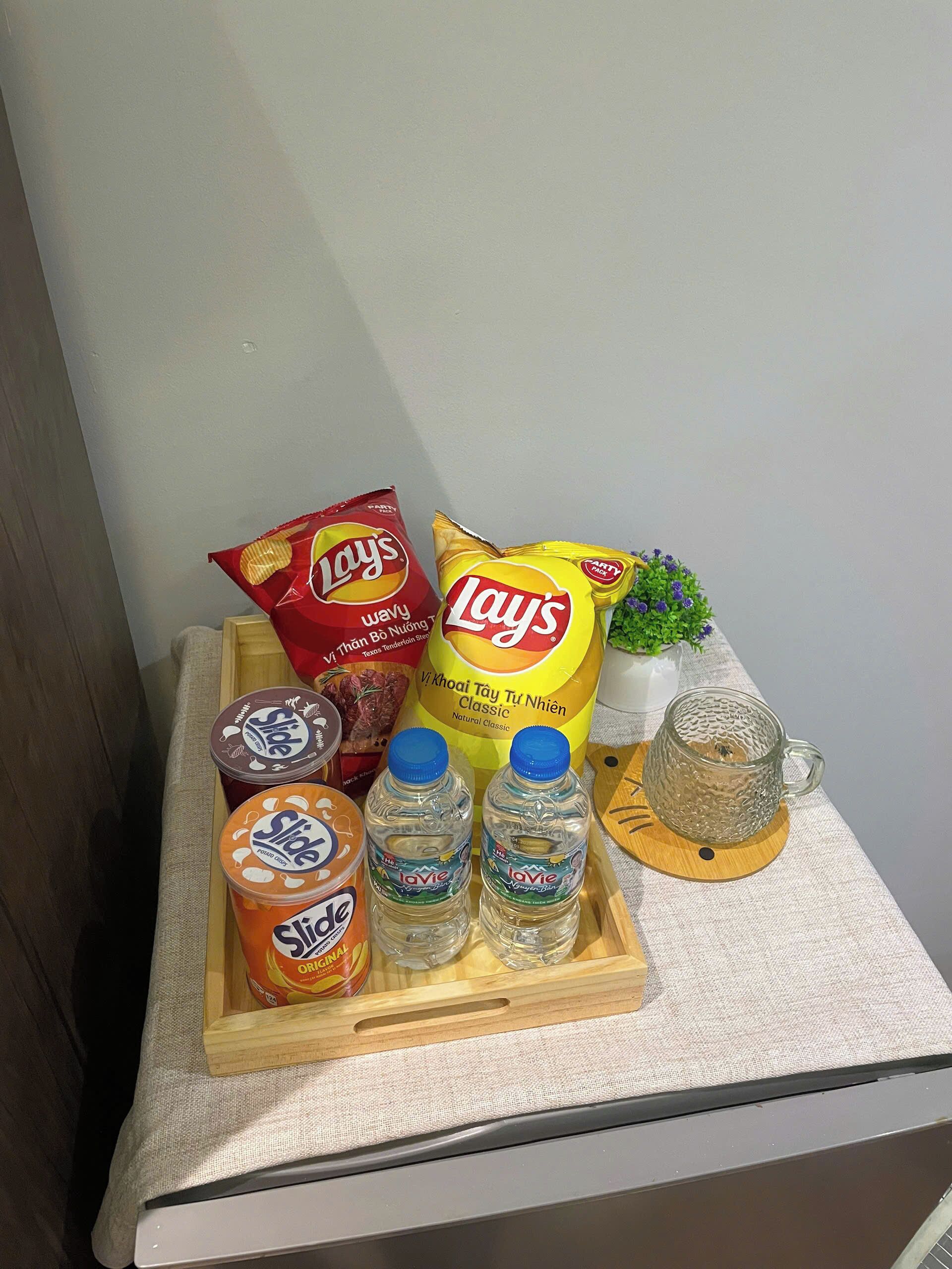 Un plateau contenant des collations, des boissons et une tasse en verre, posé sur une table.
