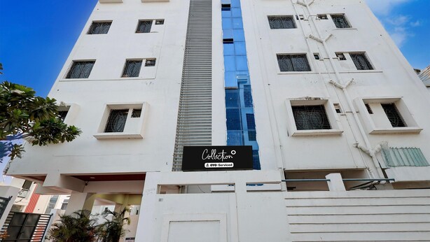 A multi-story building with a prominent vertical blue glass feature, a sign for 'Collection OYO-Serviced,' and a gated entrance. - Classic Yuva Inn (Nagpur)