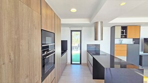 A modern kitchen with built-in appliances, a large window, and a view of the outdoors. - Villa Benidorm - Private swimming pool with sea views (VC)