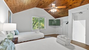 A bedroom with two beds, a ceiling fan, a window with blinds, a towel stack, and a sign for 'ROYAL STAYS'. - Ramblewood Large Fenced Yard Pets (Mt Pleasant)