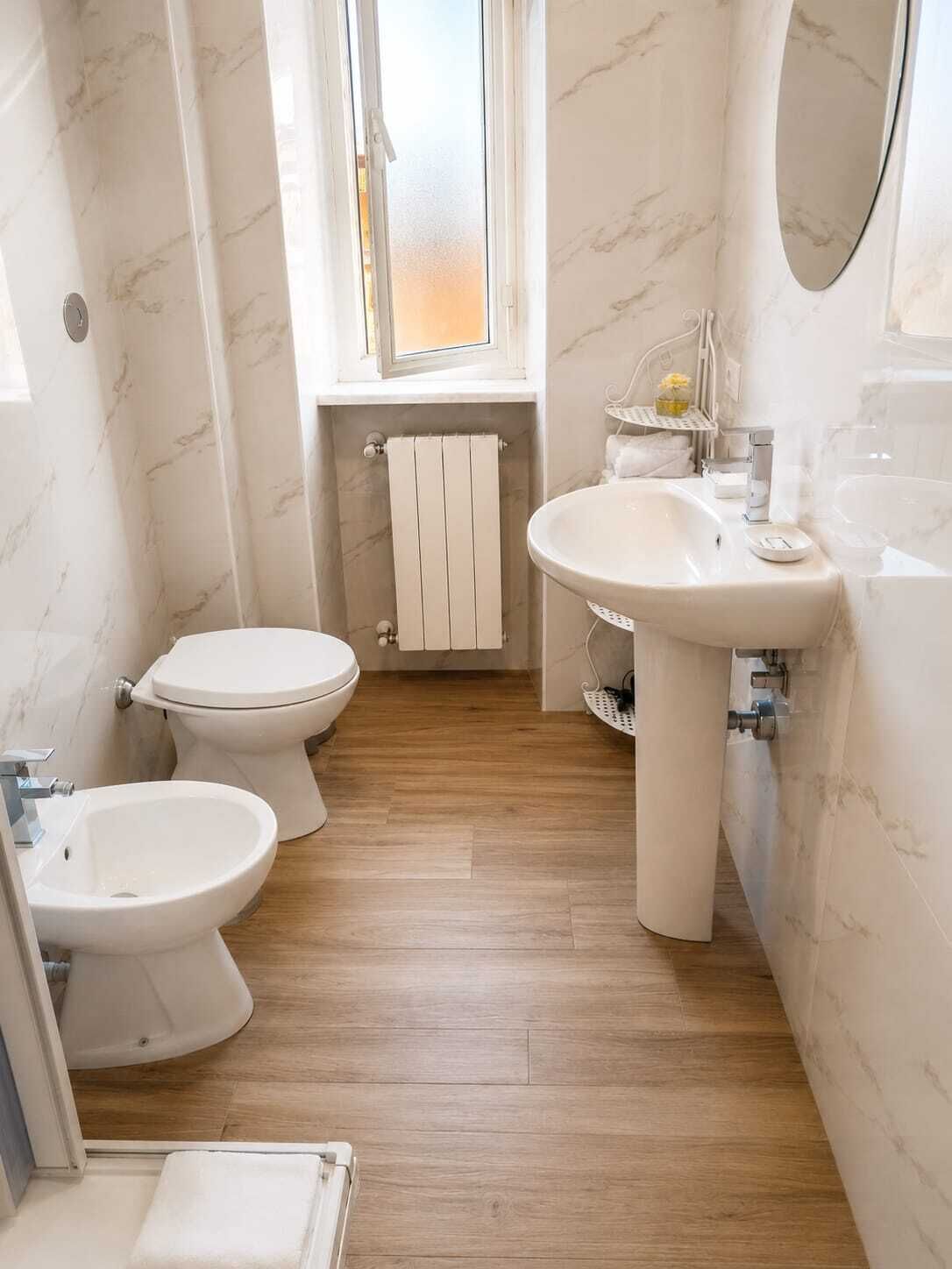 A compact bathroom with a toilet, bidet, and sink.