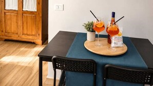 Een eetruimte met een houten kast, een klok en een tafel gedekt met een fles en glazen.