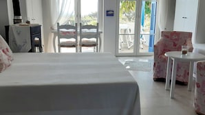 Habitación de hotel con cama, una mesita, una silla y vistas al exterior.