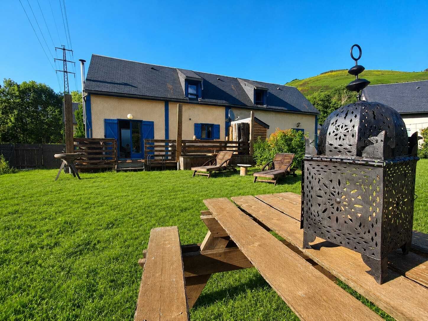 A house with a patio area, wooden furniture, and a decorative metal lantern.