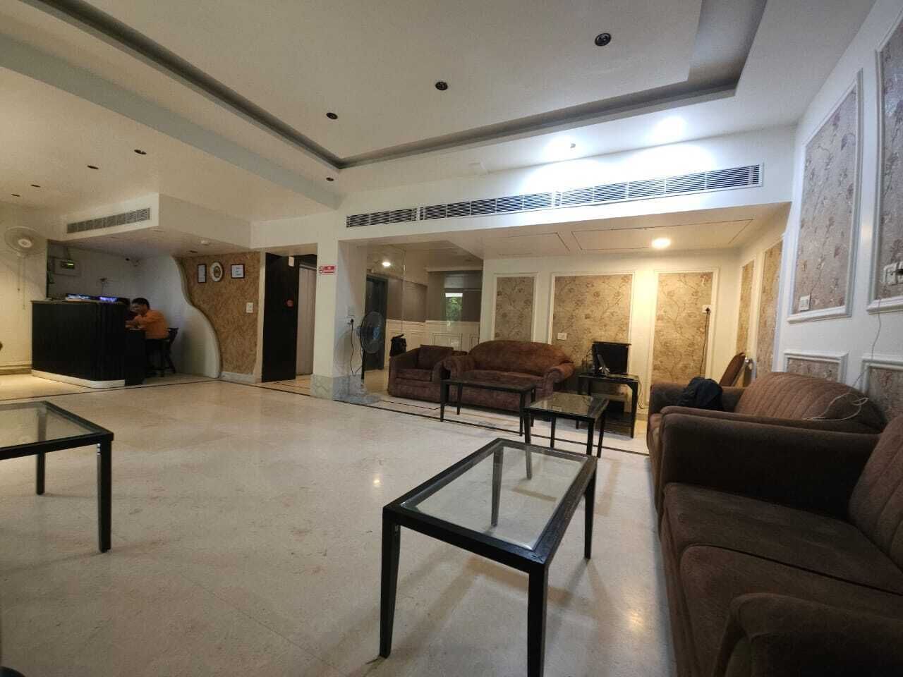 Un vestíbulo amplio con mostrador de recepción, zona de estar y chimenea.