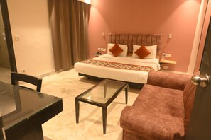 Ein Hotelzimmer mit einem Bett, einem Schreibtisch, einem Stuhl und einem Sofa.