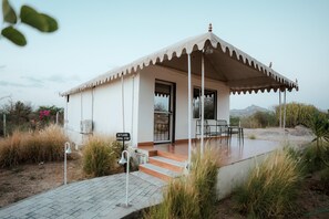Un edifici petit d'una sola planta amb un porxo cobert, un rètol que diu 'SKYLARK ROYAL STAY' i un accés pavimentat.